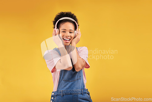 Image of African girl, headphones and studio portrait with smile, youth fashion and sound by yellow background. Young student, gen z woman or model with audio tech, streaming subscription and happy for music