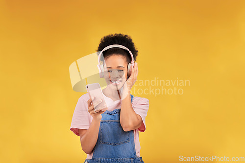 Image of Happy, music and a black woman with a phone on a studio background for a podcast or audio. Smile, space and an African girl with headphones and a mobile for an app, streaming and listening to radio