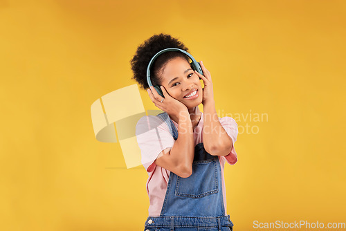 Image of Music, headphones and happy black woman in portrait listening in studio isolated on a yellow background mockup space. Face, smile and person hearing radio, podcast or sound for jazz, hip hop or audio