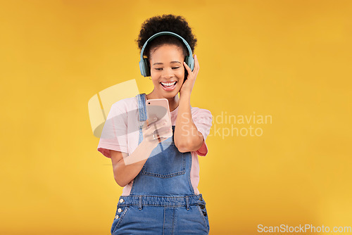 Image of Online, music and a black woman with a phone on a studio background for a podcast or audio. Smile, space and an African girl with headphones and a mobile for an app, streaming and listening to radio