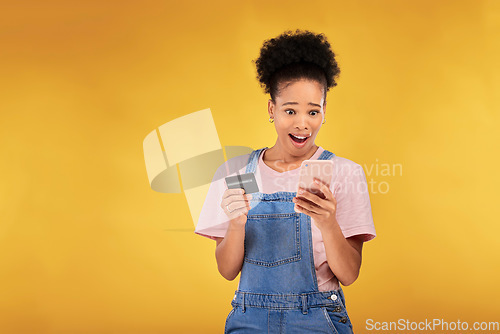 Image of Woman, credit card and wow with phone, studio and shock face for deal, discount or sale by yellow background. Gen z girl, smartphone and banking with surprise for investment, scam and fintech app