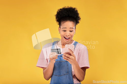 Image of Woman, credit card and surprise with phone, studio and shock face for deal, discount or sales by yellow background. Gen z girl, cell phone and banking with wow for investment, smile and fintech app