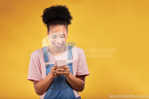 Image of Mockup, typing and happy woman with phone in studio, texting or social media post with space on yellow background. Networking, chat online and model with cellphone mobile app, reading meme or email