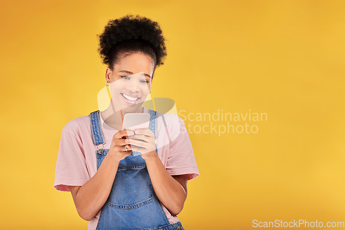 Image of Smile, typing and woman with phone in studio, texting or social media post with mockup on yellow background. Networking, chat online and happy model with cellphone mobile app, reading meme or email