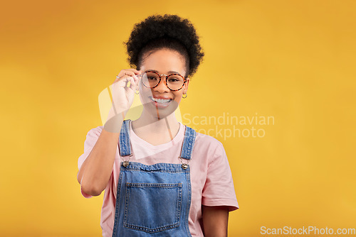 Image of Portrait, glasses and smile with a black woman on a yellow background in studio for vision. Fashion, eyewear and a happy young afro female student at the optometrist for frame lenses or spectacles