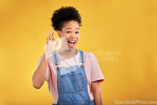 Image of Portrait, okay and hand gesture with a happy black woman in studio on a yellow background. Smile, wow and perfect with an excited young female person showing a sign of support, feedback or review