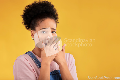 Image of Shocked, surprise and portrait of woman with wow reaction to news isolated in a yellow studio background. Expression, omg and young female person covering mouth due to gossip or announcement