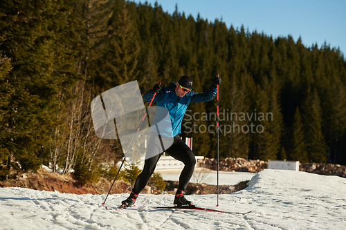 Image of Nordic skiing or Cross-country skiing classic technique practiced by man in a beautiful panoramic trail at morning.Selective focus.