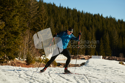 Image of Nordic skiing or Cross-country skiing classic technique practiced by man in a beautiful panoramic trail at morning.Selective focus.