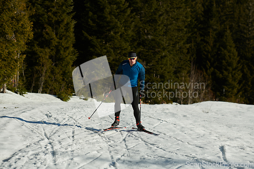 Image of Nordic skiing or Cross-country skiing classic technique practiced by man in a beautiful panoramic trail at morning.Selective focus.