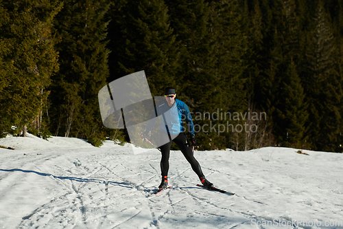 Image of Nordic skiing or Cross-country skiing classic technique practiced by man in a beautiful panoramic trail at morning.Selective focus.