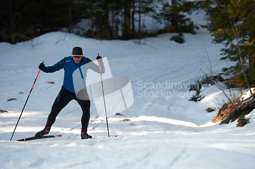 Image of Nordic skiing or Cross-country skiing classic technique practiced by man in a beautiful panoramic trail at morning.Selective focus.