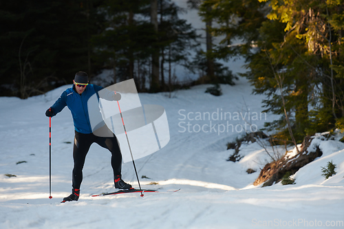 Image of Nordic skiing or Cross-country skiing classic technique practiced by man in a beautiful panoramic trail at morning.Selective focus.