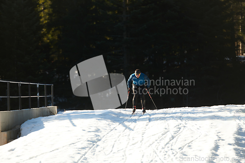 Image of Nordic skiing or Cross-country skiing classic technique practiced by man in a beautiful panoramic trail at morning.Selective focus.