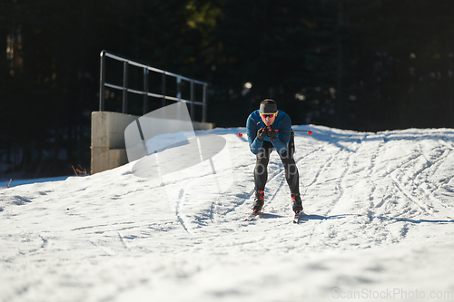 Image of Nordic skiing or Cross-country skiing classic technique practiced by man in a beautiful panoramic trail at morning.Selective focus.