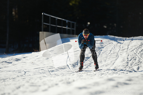 Image of Nordic skiing or Cross-country skiing classic technique practiced by man in a beautiful panoramic trail at morning.Selective focus.