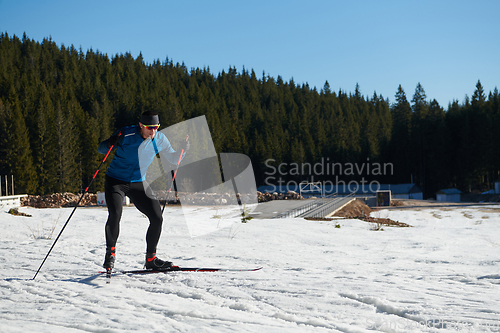 Image of Nordic skiing or Cross-country skiing classic technique practiced by man in a beautiful panoramic trail at morning.Selective focus.