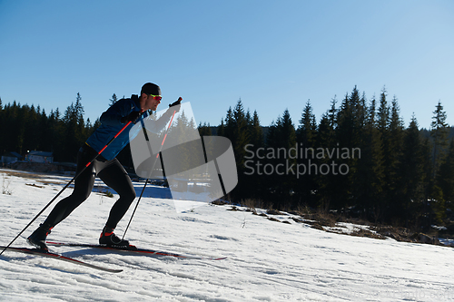 Image of Nordic skiing or Cross-country skiing classic technique practiced by man in a beautiful panoramic trail at morning.Selective focus.