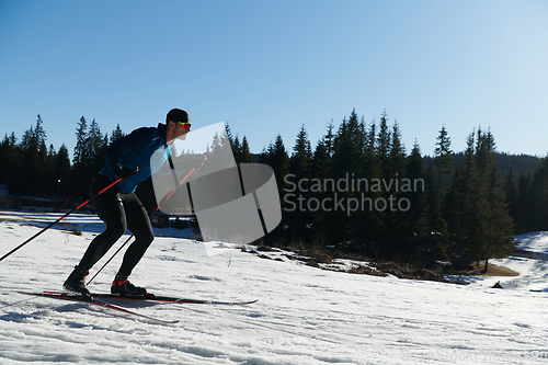 Image of Nordic skiing or Cross-country skiing classic technique practiced by man in a beautiful panoramic trail at morning.Selective focus.