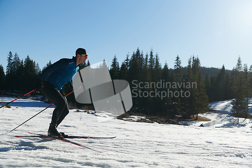 Image of Nordic skiing or Cross-country skiing classic technique practiced by man in a beautiful panoramic trail at morning.Selective focus.