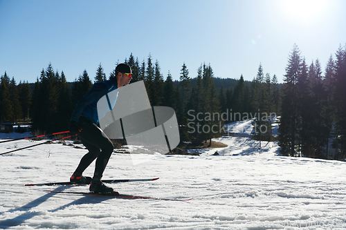 Image of Nordic skiing or Cross-country skiing classic technique practiced by man in a beautiful panoramic trail at morning.Selective focus.