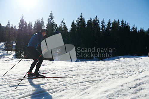 Image of Nordic skiing or Cross-country skiing classic technique practiced by man in a beautiful panoramic trail at morning.Selective focus.