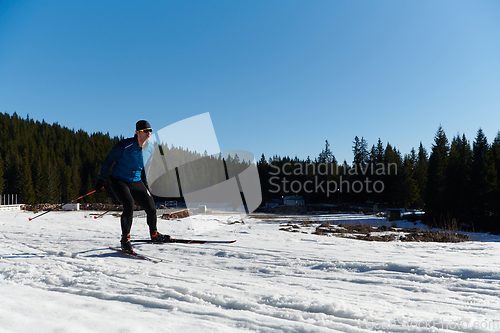 Image of Nordic skiing or Cross-country skiing classic technique practiced by man in a beautiful panoramic trail at morning.Selective focus.