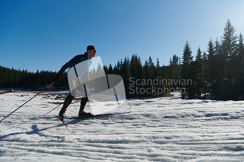 Image of Nordic skiing or Cross-country skiing classic technique practiced by man in a beautiful panoramic trail at morning.Selective focus.