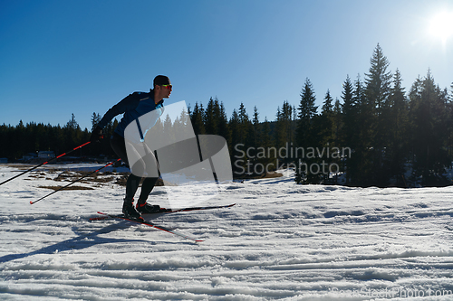 Image of Nordic skiing or Cross-country skiing classic technique practiced by man in a beautiful panoramic trail at morning.Selective focus.