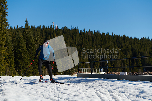 Image of Nordic skiing or Cross-country skiing classic technique practiced by man in a beautiful panoramic trail at morning.Selective focus.