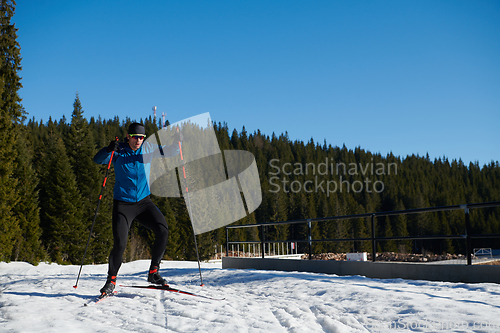 Image of Nordic skiing or Cross-country skiing classic technique practiced by man in a beautiful panoramic trail at morning.Selective focus.