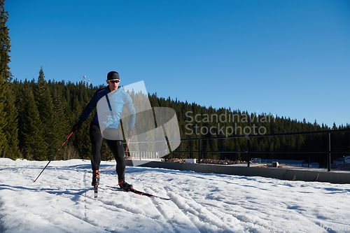 Image of Nordic skiing or Cross-country skiing classic technique practiced by man in a beautiful panoramic trail at morning.Selective focus.