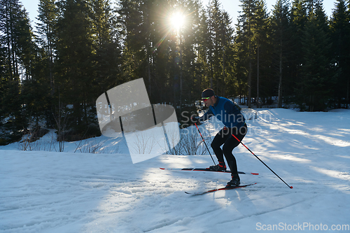 Image of Nordic skiing or Cross-country skiing classic technique practiced by man in a beautiful panoramic trail at morning.Selective focus.