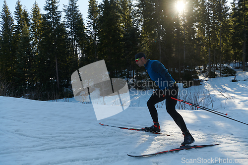 Image of Nordic skiing or Cross-country skiing classic technique practiced by man in a beautiful panoramic trail at morning.Selective focus.