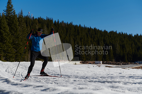 Image of Nordic skiing or Cross-country skiing classic technique practiced by man in a beautiful panoramic trail at morning.Selective focus.