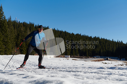 Image of Nordic skiing or Cross-country skiing classic technique practiced by man in a beautiful panoramic trail at morning.Selective focus.