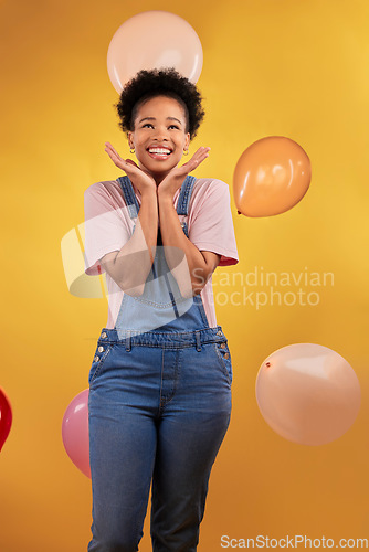 Image of Balloons, wow and happy woman on birthday, prize or giveaway success, winning and celebration. Party, excited and young african person or gen z winner, competition or sale on yellow studio background