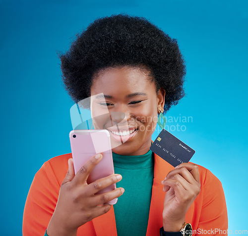 Image of Black woman, credit card and phone in studio, smile or thinking for choice, ecommerce and blue background. Gen z African girl, smartphone and fintech app for payment, cybersecurity or online shopping