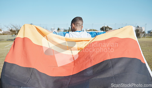 Image of Germany, sports and man with a flag for soccer, motivation and training on a field. Back, fitness and professional athlete or person with representation of a country at a football game or competition