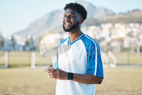 Image of Fitness, phone or soccer player on field on social media, blog post or texting on internet or online chat. Black man, football or happy African athlete thinking of mobile app in match or sports game