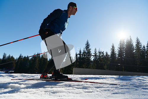 Image of Nordic skiing or Cross-country skiing classic technique practiced by man in a beautiful panoramic trail at morning.Selective focus.