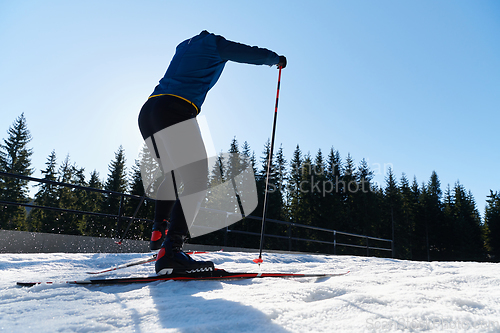 Image of Nordic skiing or Cross-country skiing classic technique practiced by man in a beautiful panoramic trail at morning.Selective focus.