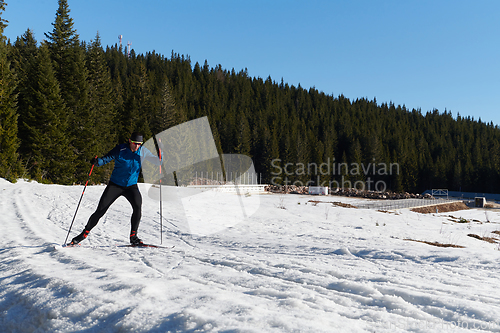 Image of Nordic skiing or Cross-country skiing classic technique practiced by man in a beautiful panoramic trail at morning.Selective focus.