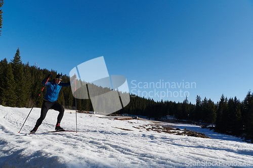 Image of Nordic skiing or Cross-country skiing classic technique practiced by man in a beautiful panoramic trail at morning.Selective focus.