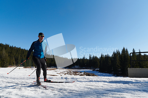 Image of Nordic skiing or Cross-country skiing classic technique practiced by man in a beautiful panoramic trail at morning.Selective focus.