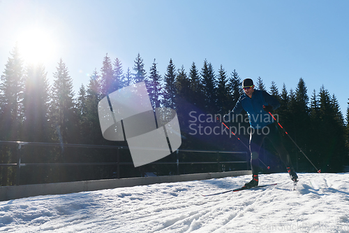 Image of Nordic skiing or Cross-country skiing classic technique practiced by man in a beautiful panoramic trail at morning.Selective focus.