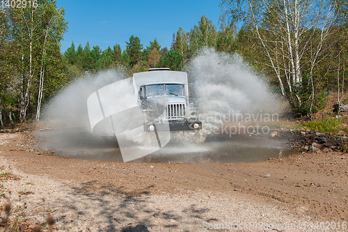Image of truck passes through a puddle