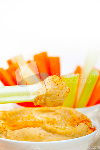 Image of fresh hummus dip with raw carrot and celery