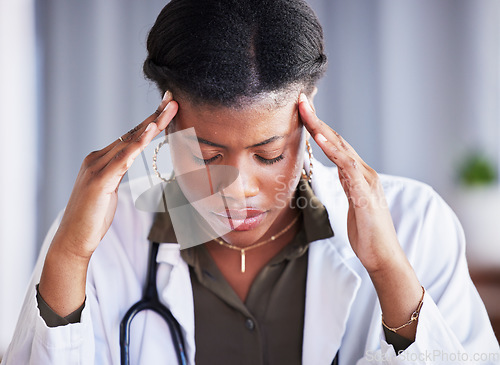 Image of Tired doctor, black woman and stress with headache at clinic, office and thinking with pain at job. Overworked medic, fatigue and burnout in hospital, worry or anxiety for mental health in wellness