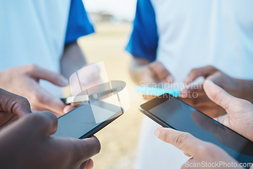 Image of Hands, phone and networking with sports people in a huddle for communication or connectivity. Mobile, social media or information sharing with a person group standing in a circle closeup outdoors